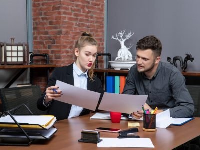 top-view-young-busy-motivated-clerical-workers-discussing-one-issue-documents-office_140725-106281